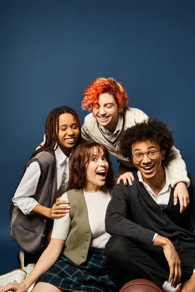 Multicultural group of friends posing together in stylish attire against a dark blue background. — Stock Photo