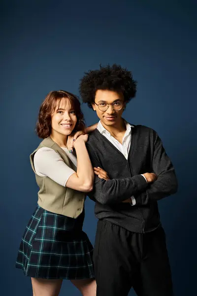 A man and a woman, pose in stylish attire against a dark blue background. — Stock Photo
