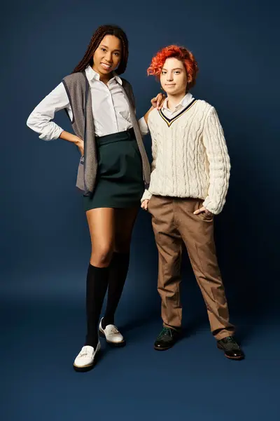 Multicultural young friends, stand together in stylish attire against a dark blue backdrop. — Stock Photo