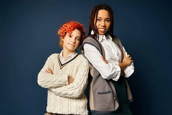 Friends in stylish attire stand together, showcasing diversity and unity on a dark blue background. — Stock Photo