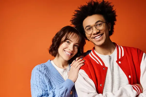 A young multicultural man and woman stand united in stylish attire in a studio setting. — Stock Photo