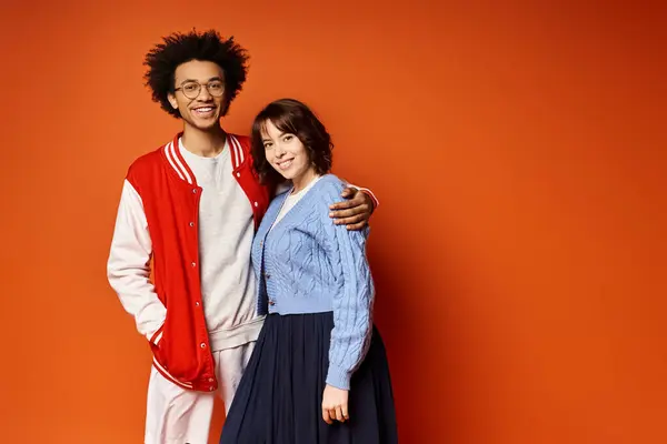 A man and a woman, along with a nonbinary person, stand together in stylish attire in a studio setting, portraying unity and friendship. — Stock Photo
