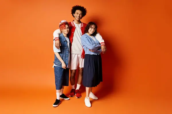 A diverse group of young friends, including a nonbinary person, stand together in stylish attire in a studio setting. — Stock Photo