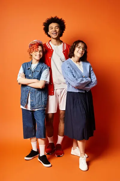 A group of young multicultural friends, including a nonbinary person, standing together in stylish attire in a studio setting. — Stock Photo