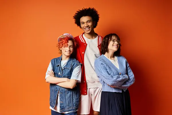 Multicultural group of friends, including a nonbinary person, standing together in stylish attire in a studio setting. — Stock Photo