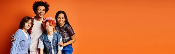 Young interracial friends, including a nonbinary person, stand together in stylish attire in a studio setting. — Stock Photo