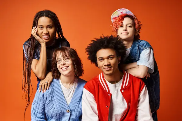 A young, diverse group in trendy outfits pose for a portrait in a studio setting, including a nonbinary individual. — Stock Photo