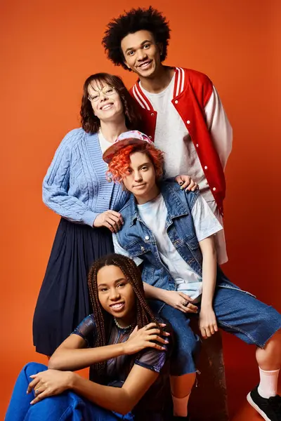 A diverse group of young friends, including a nonbinary person, posing stylishly for a group picture in a studio setting. — стоковое фото