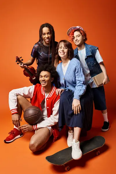 A diverse group of young friends in stylish attire having fun sitting together on top of a skateboard in a studio setting. — Stock Photo