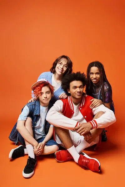 A group of young multicultural friends, including a nonbinary person, standing together in stylish attire, striking a pose for a photo. — Stock Photo