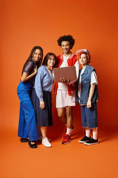 Les jeunes amis multiculturels, y compris une personne non binaire, se tiennent ensemble dans une tenue élégante dans un cadre de studio. — Photo de stock