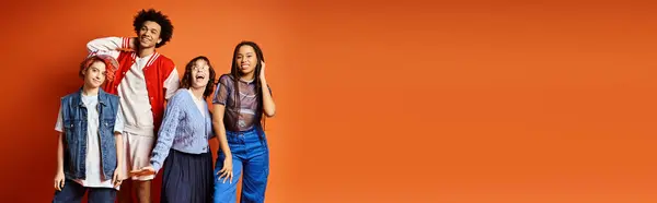 A diverse group of friends, including a nonbinary person, stand together in stylish attire in a studio setting. — Stock Photo