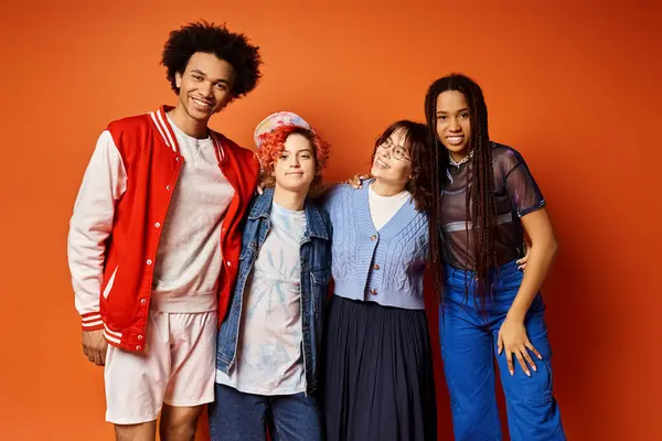 Amigos multiculturales, incluyendo un individuo no binario, se unen en un atuendo de moda en un entorno de estudio. - foto de stock