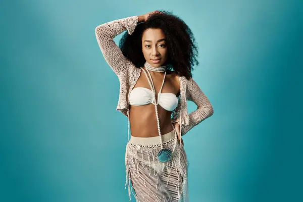 Stylish African American woman in white swimsuit posing gracefully against a vibrant blue backdrop. — Stock Photo