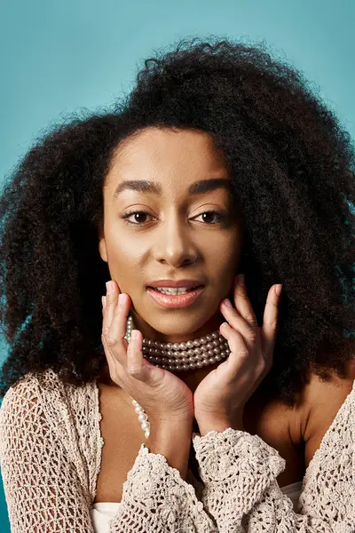 Stylish young woman with curly hairdo striking a pose on blue background. — Stock Photo