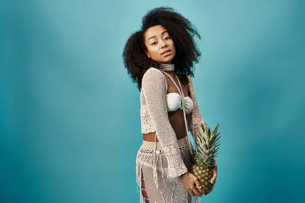 Stylish African American woman in trendy swimsuit poses with pineapple. — Foto stock