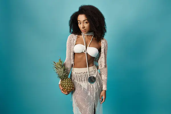 Elegante giovane donna afroamericana in bikini con in mano un ananas. — Foto stock