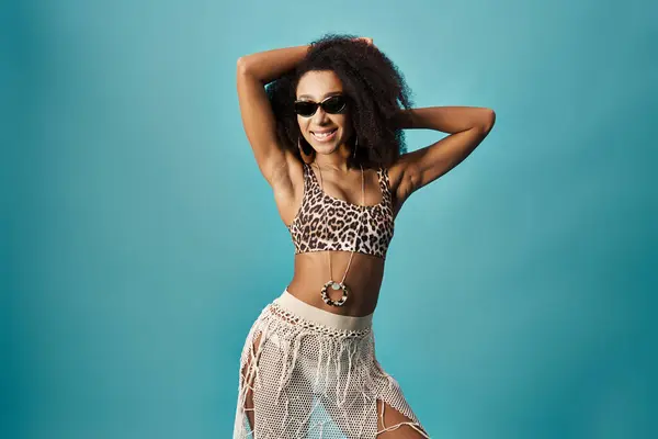Mulher afro-americana elegante no topo de impressão leopardo e saia marcando uma pose no fundo azul. — Fotografia de Stock