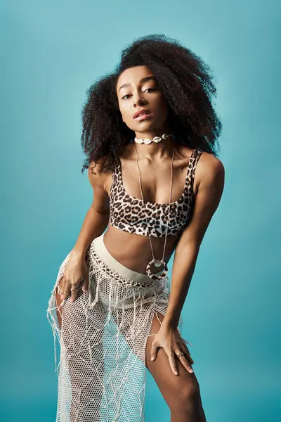 Mulher afro-americana no topo impressão leopardo posando contra fundo azul. — Fotografia de Stock