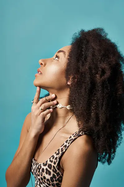 Joven mujer afroamericana con peinado rizado en elegante traje de baño posa con la mano en la barbilla. — Stock Photo