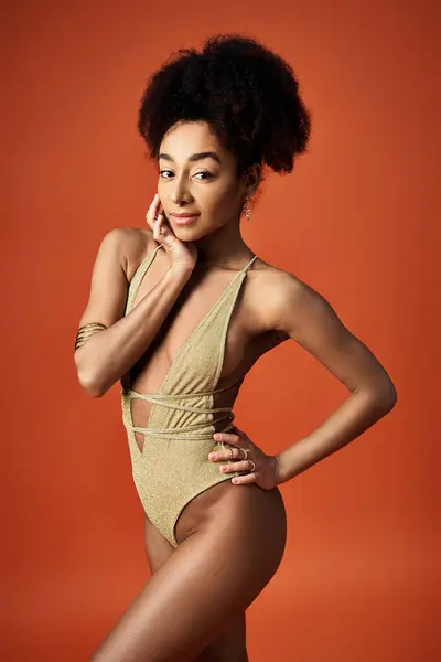 Young African American woman in gold swimsuit posing elegantly. — Stock Photo
