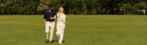 Чоловік і жінка в елегантному вбранні стоять разом у пишному зеленому полі, втілюючи розкішний і витончений спосіб життя. — стокове фото