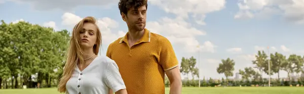 A stylish man and woman stand in a lush field, embodying old money sophistication in their elegant attire. — Stock Photo