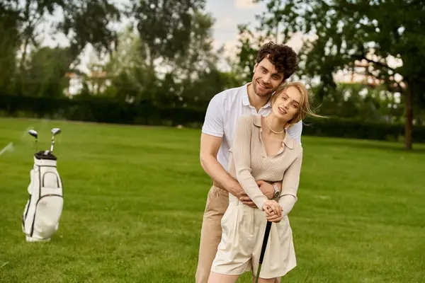 A stylish man and woman are posing elegantly on a golf course, exuding sophistication and class in their attire. — стокове фото