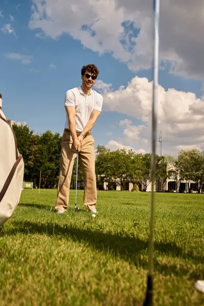 Una giovane coppia elegante gioca a golf su un lussureggiante campo verde, godendo di una giornata di svago all'aria aperta in abiti eleganti. — Foto stock