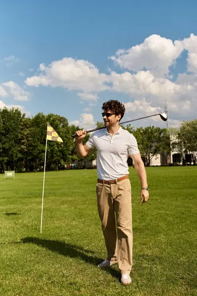 Um homem de traje elegante joga golfe em um campo verde exuberante, incorporando o estilo clássico de lazer de classe alta. — Fotografia de Stock