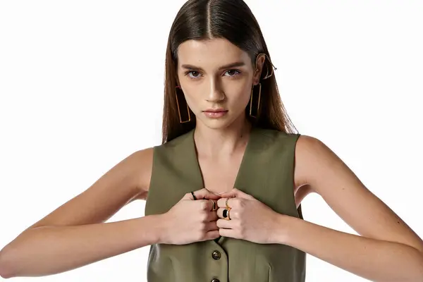 A chic woman with dark hair wears a green shirt, gracefully joining her hands together. — Stock Photo