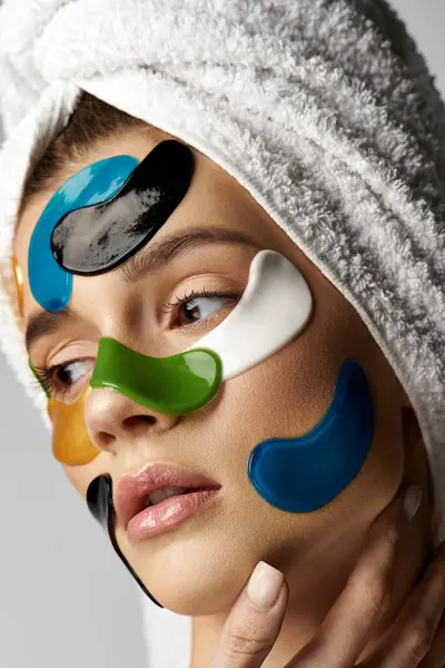 Eine Frau mit einem Handtuch auf dem Kopf und Augenklappen im Gesicht, die eine ruhige und transformative Schönheitsroutine zeigt. — Stockfoto
