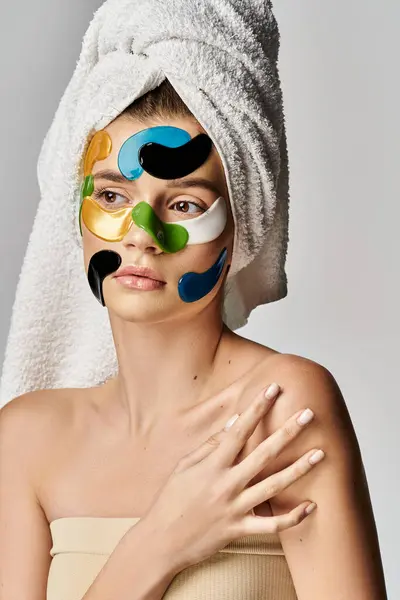 Mulher atraente com uma toalha e manchas nos olhos, incorporando relaxamento e autocuidado em um ambiente sereno. — Fotografia de Stock