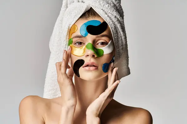 Tasteful woman with a towel wrapped around her head and eye patches. — Stock Photo