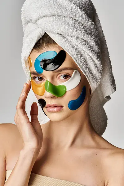 Mujer de moda con una toalla envuelta alrededor de su cabeza y parches para los ojos. - foto de stock