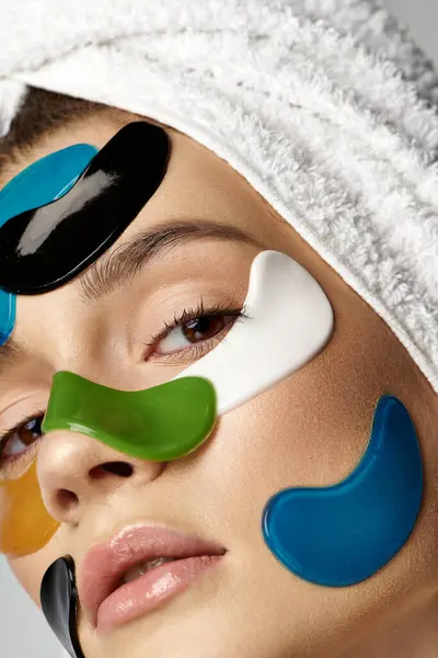 Uma jovem graciosa está usando um turbante de toalha na cabeça e manchas delicadas nos olhos, mostrando uma rotina de beleza.. — Fotografia de Stock
