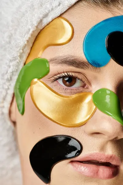Appealing young woman with a towel wrapped around her head and eye patches. — Stock Photo