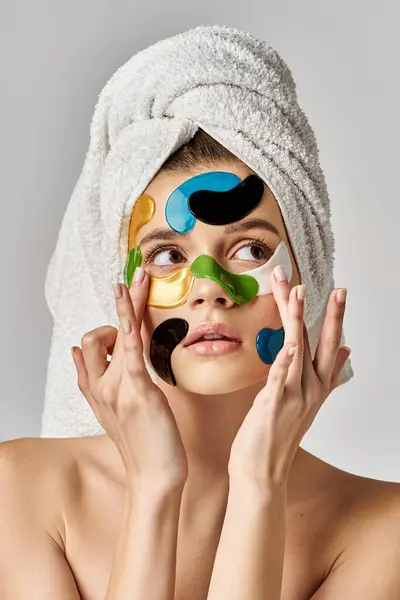 Uma jovem mulher com uma toalha na cabeça com manchas nos olhos no rosto. — Fotografia de Stock