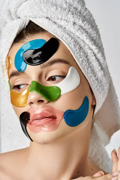 Eine atemberaubende Frau posiert sanft mit einem Handtuch auf dem Kopf und mit Augenklappen verziert. — Stockfoto