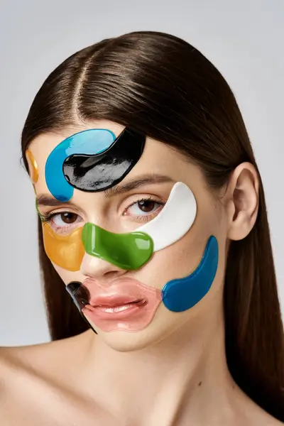 Молодая женщина позирует с повязками на лице, демонстрируя свою творческую и творческую трансформацию. — стоковое фото