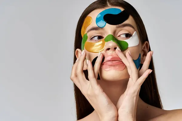 Eine junge Frau mit Augenklappen auf Gesicht und Händen hält sie in einer gelassenen Pose zart vor ihr Gesicht. — Stockfoto