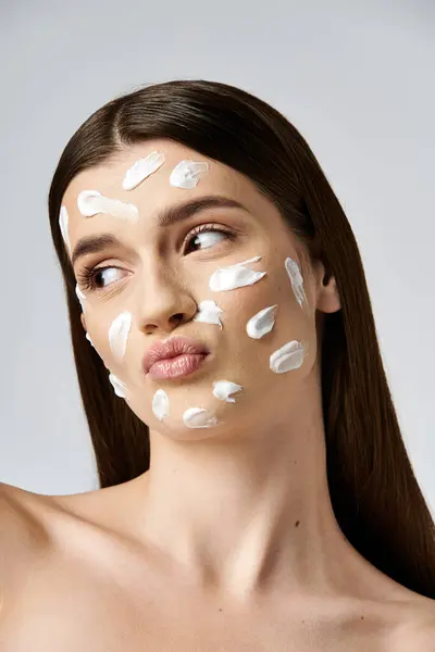 Eine junge Frau schwelgt mit einer reichhaltigen Creme im Gesicht in einer entspannten Hautpflege-Routine. — Stockfoto