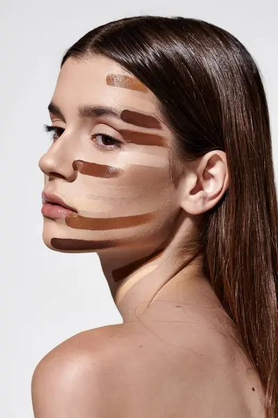 Attraktive junge Frau schmückt sich mit Schichten von Fundamenten und präsentiert komplizierte Make-up-Artistik. — Stockfoto