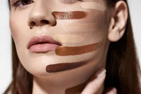 Mulher atraente mostra sua beleza com maquiagem em seu rosto, incluindo fundação. — Fotografia de Stock