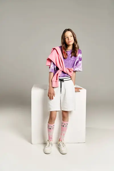 Une belle adolescente pose activement dans une tenue élégante composée d'une chemise violette et d'un short blanc. — Photo de stock