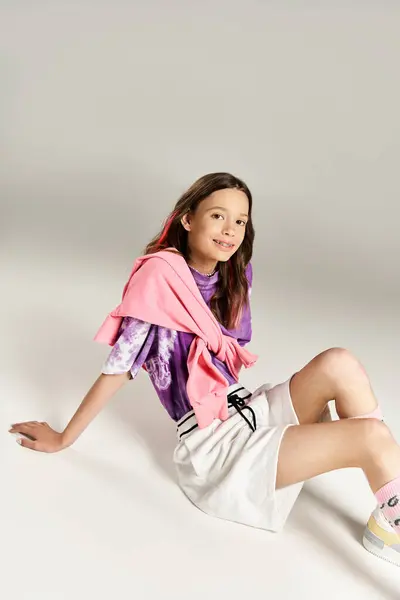 Uma menina adolescente elegante em trajes vibrantes marcando uma pose confiante para uma imagem. — Fotografia de Stock
