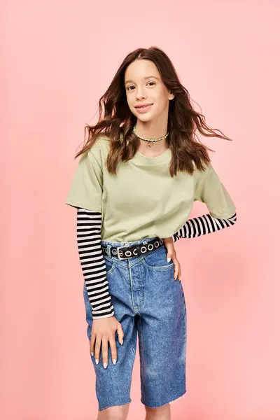 Une adolescente élégante et belle pose activement dans une chemise verte et un short bleu. — Photo de stock