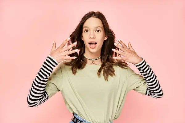 A vibrant, stylish teenage girl energetically raises her hands in the air with a look of pure joy and confidence. — Stock Photo
