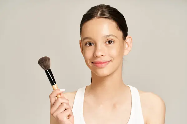 Ein stilvolles Teenager-Mädchen hält einen Make-up-Pinsel in der Hand und macht sich bereit, Make-up aufzutragen. — Stockfoto