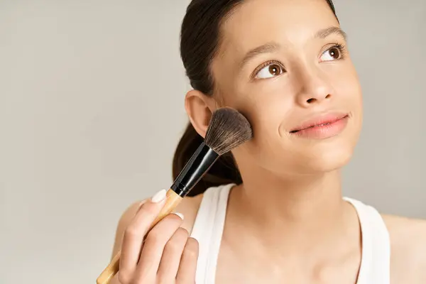 Ein stilvolles Teenager-Mädchen in lebendiger Kleidung hält leidenschaftlich einen Make-up-Pinsel in der Hand. — Stockfoto